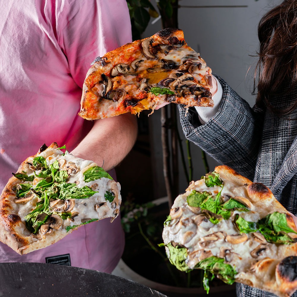 בחורות מחזיקות משולשי פיצה עם תוספות שונות