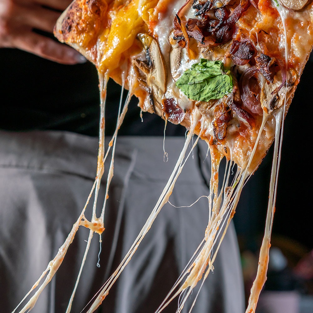 משולש פיצה עם גבינה צהובה נמתחת